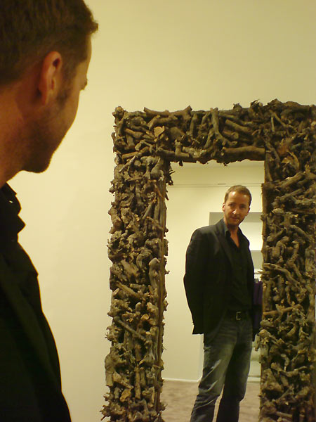 fig.: Wolfgang Olzinger in front of a mirror with a frame made of wild wood from the forest in the BR-Fashion Concept store. Wolfgang has found the mirror in Paris. In the new store it serves the customers at the 'Outdoor' section a quasi-authentic surrounding to check if the Geospirit jacket with the True Religion jeans is looking good in practice. I liked the way he is measuring himself in front of the mirror and captured the moment with the camera of my mobile. 