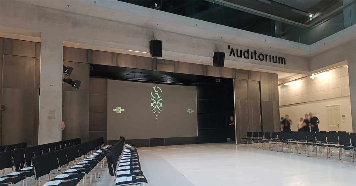 View of the auditorium before the 2024 Angewandte fashion show, showing audience seating and stage setup under the direction of Craig Green.