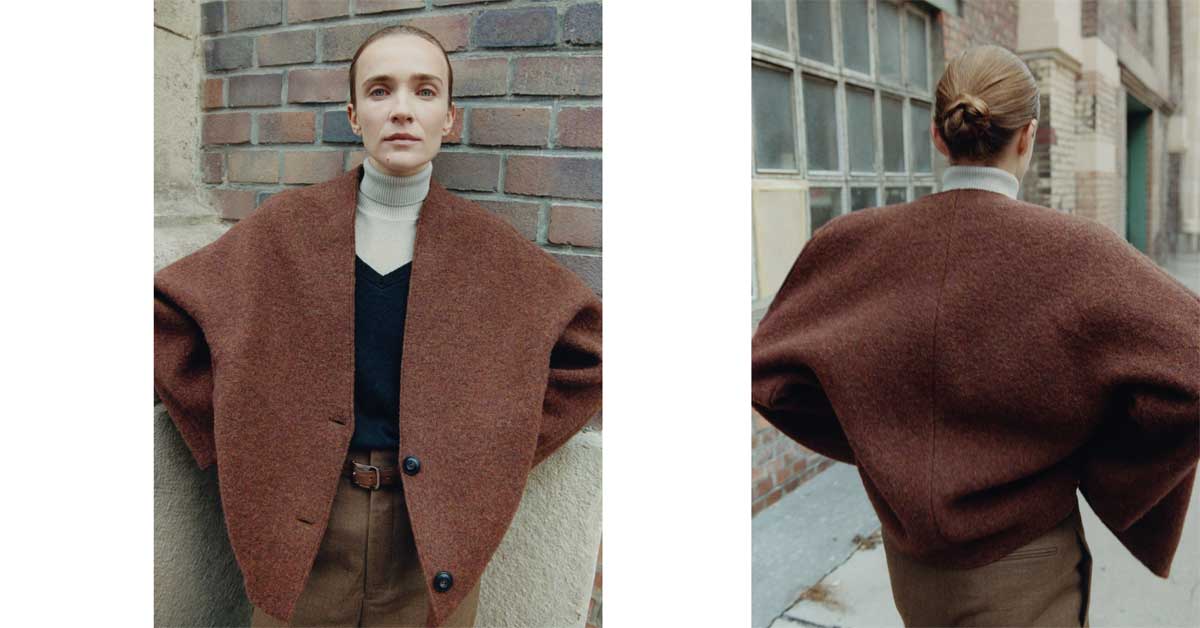 Cape-jacket in autumn-red from Stapf FW25, front and back view against an urban brick wall.