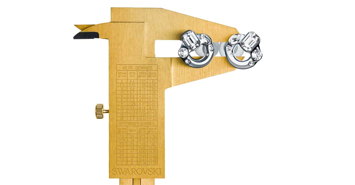Caliper holding crystal-studded Loop Earplugs from the Swarovski Creators Lab, symbolizing the fusion of precision, sound protection, and design.