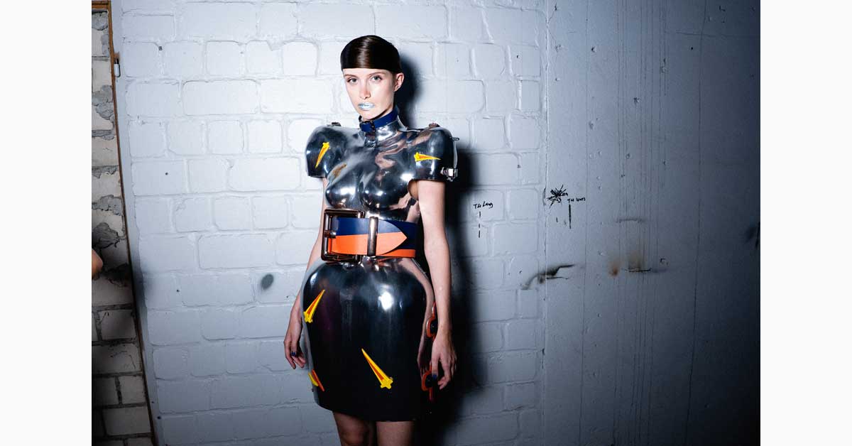 Model wearing a sculptural silver dress inspired by Capri-Sun pouches during the 'Outer Space' Spring/Summer 2027 runway show at Berlin Fashion Week.