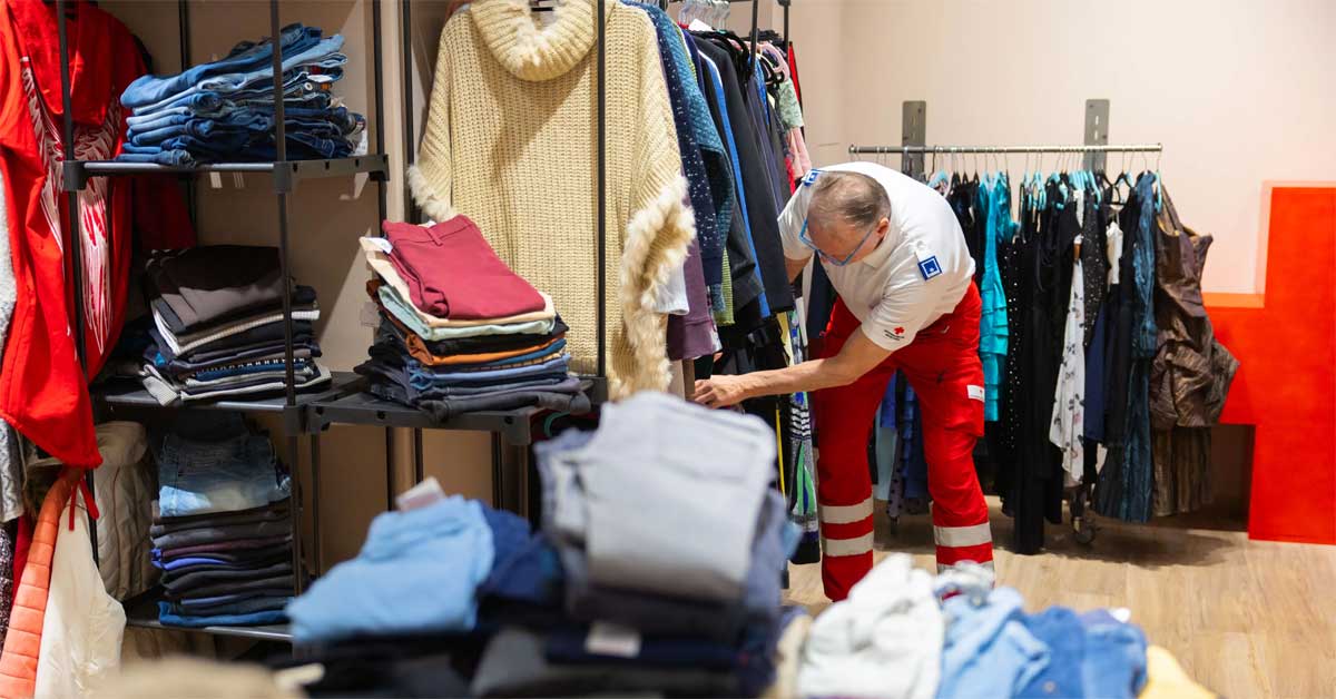 Team member of the Vienna Red Cross sorting donated clothing inside the Henry second-hand pop-up at Huma Eleven.