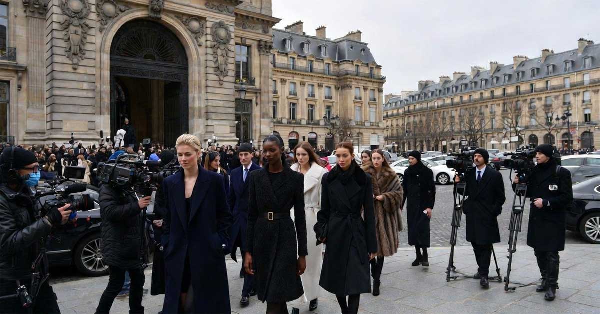 Guests arriving at Paris Haute Couture Week amid media coverage.