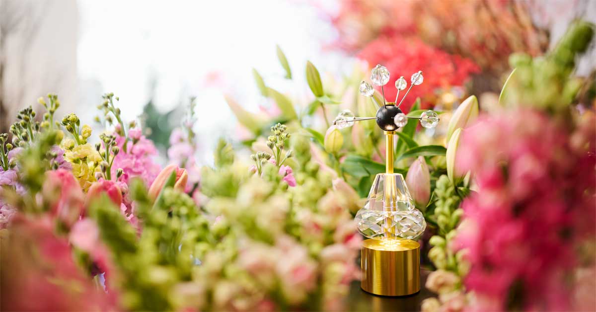 Crystal portable lamp by Lobmeyr surrounded by pink and green spring flowers in Vienna studio setting