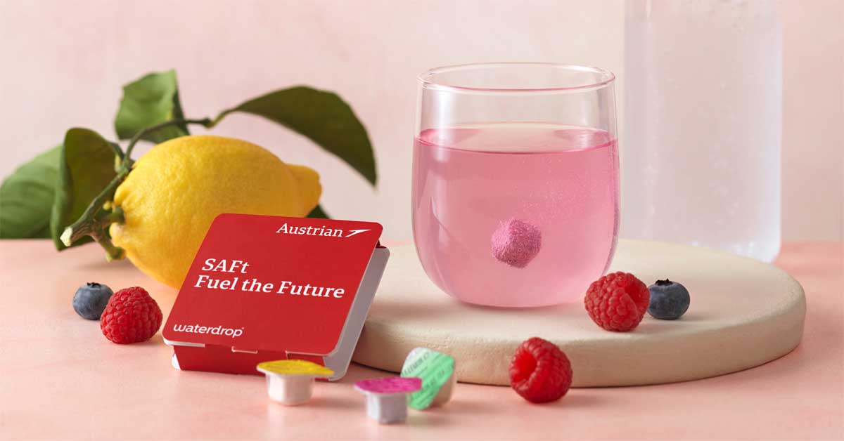 SAFt package from Austrian Airlines and waterdrop® with the slogan 'Fuel the Future,' next to a glass of water, a lemon, and berries. Photo: © Austrian Airlines