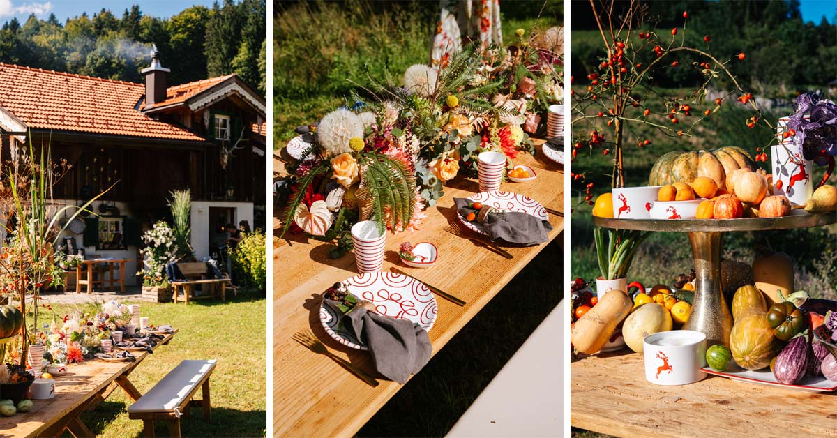 Autumn harvest table with red Gmundner ceramics, deer motifs, pumpkins and natural foliage.