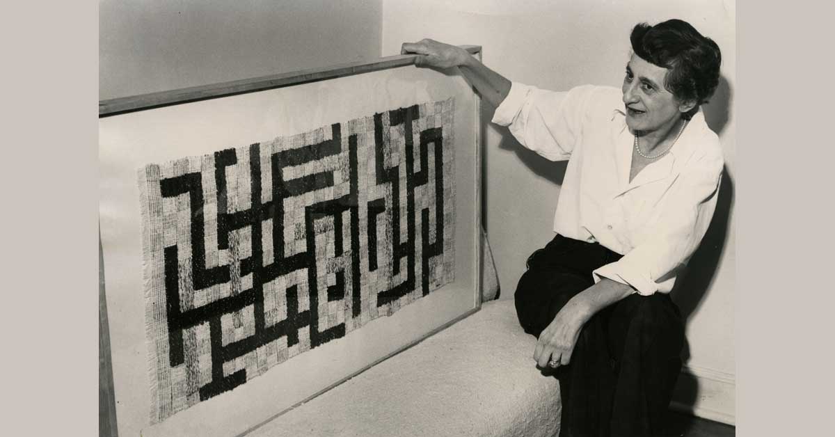 Anni Albers seated next to her geometric woven textile 'Two', photographed in New Haven in 1952.