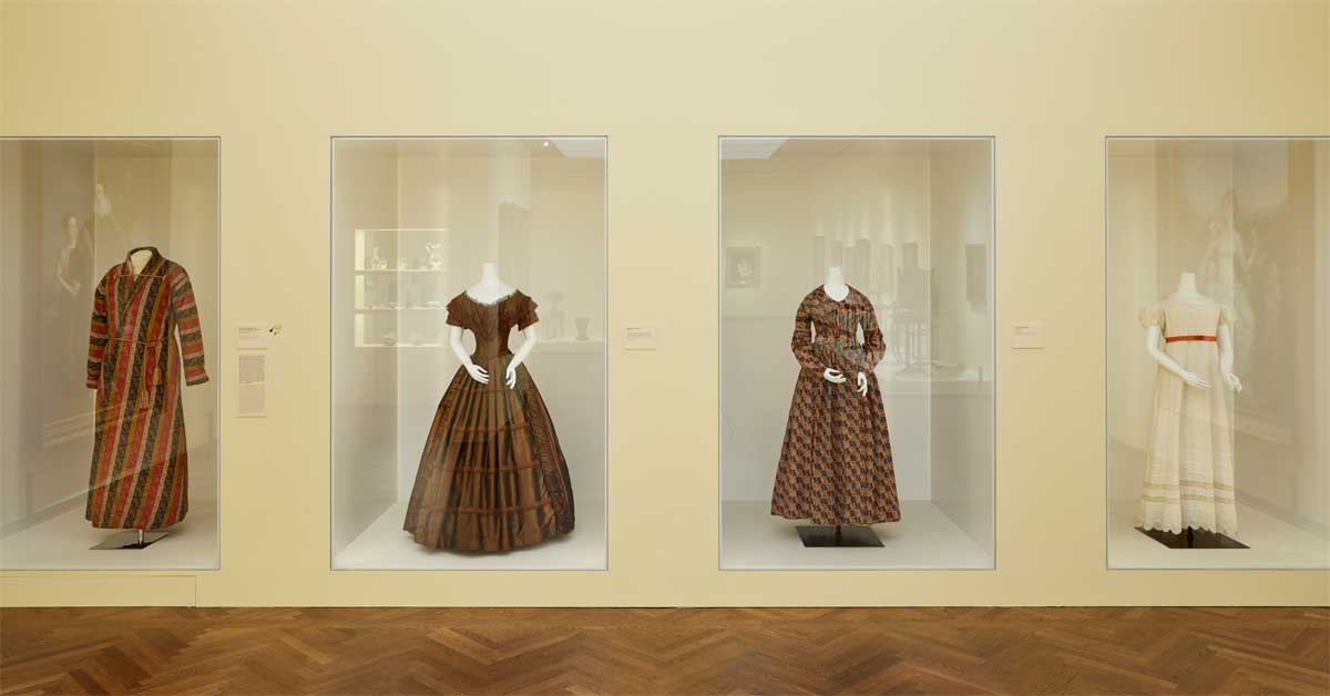 Exhibition view at the Leopold Museum with four original Biedermeier-era garments on display.