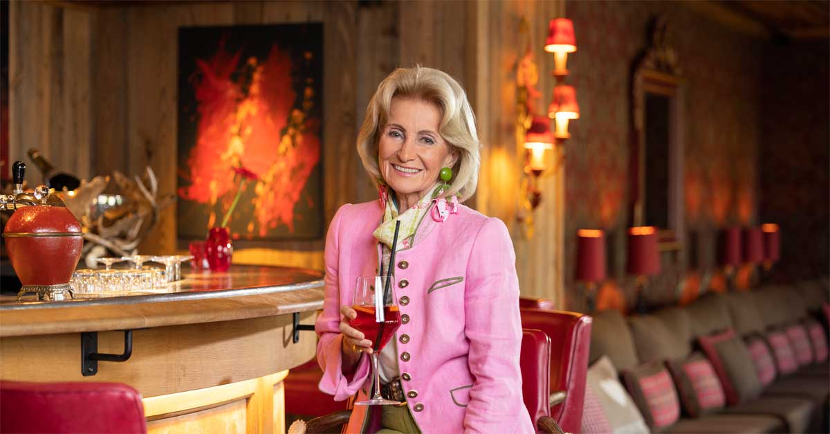 Elisabeth Gürtler in pink blazer holding champagne glass at Alpin Resort Sacher Seefeld, photographed by David Johansson