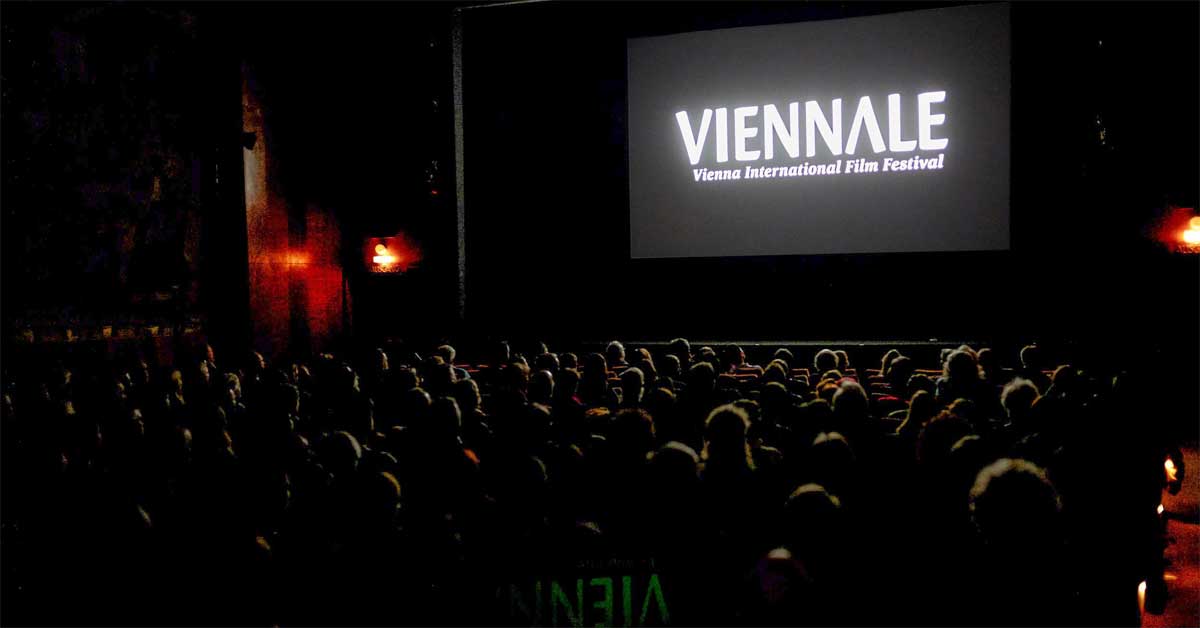 Audience watching the Viennale opening screen in a cinema hall.