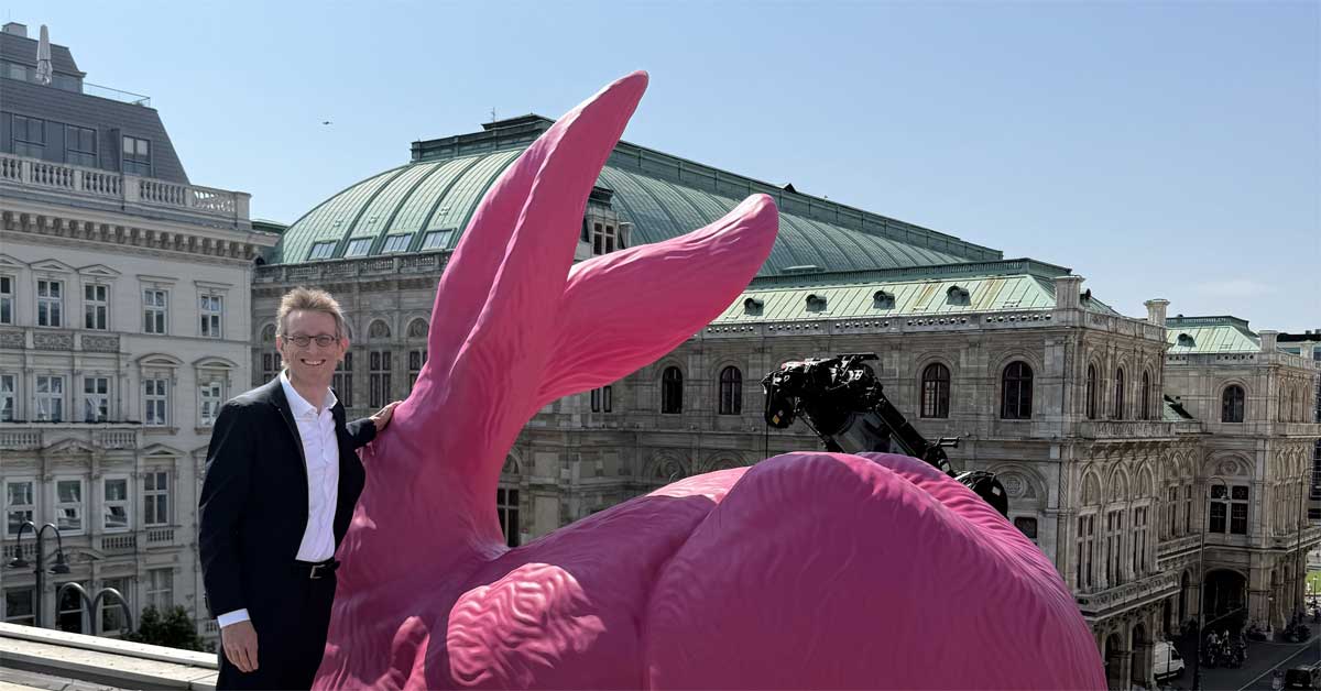 Albertina Director General Ralph Gleis with Ottmar Hörl's giant pink Dürer hare on the museum roof in Vienna.