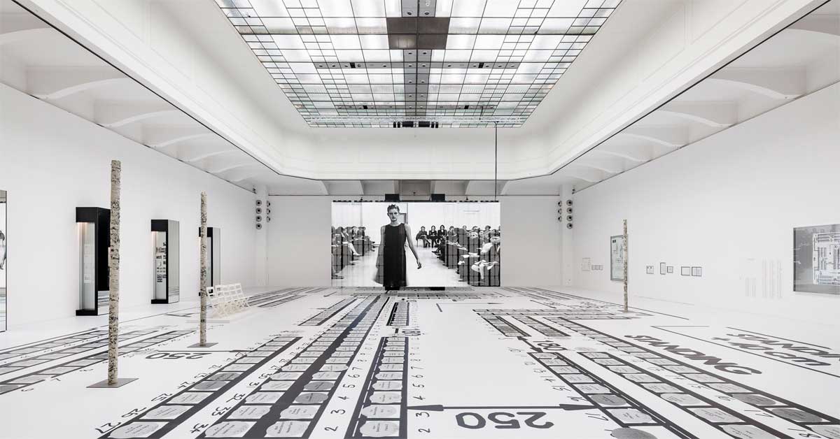 Installation view of Helmut Lang exhibition at MAK Vienna with runway projection and graphic floor design