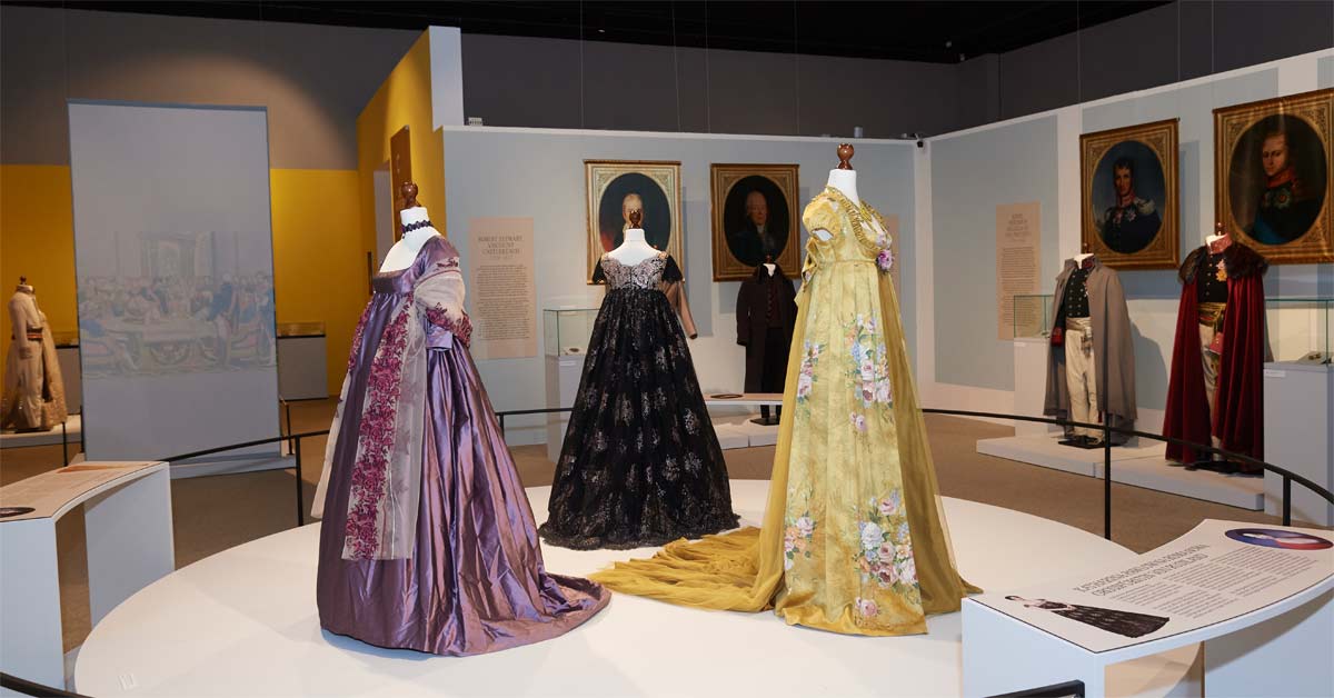 Purple, black and yellow historical-style gowns displayed at Schloss Halbturn's Love & Power exhibition.