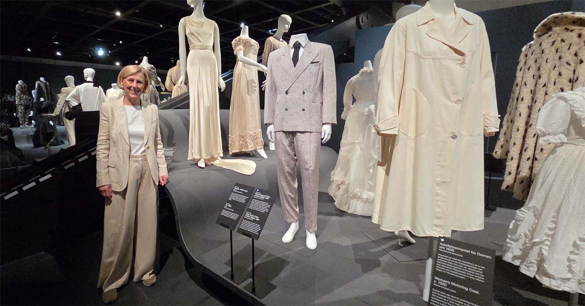 Michaela Lindinger stands beside the Falco suit designed by Helmut Lang