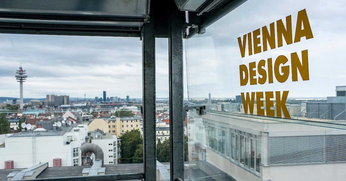 Vienna city view through a window with Vienna Design Week lettering, representing the festival's international outlook.