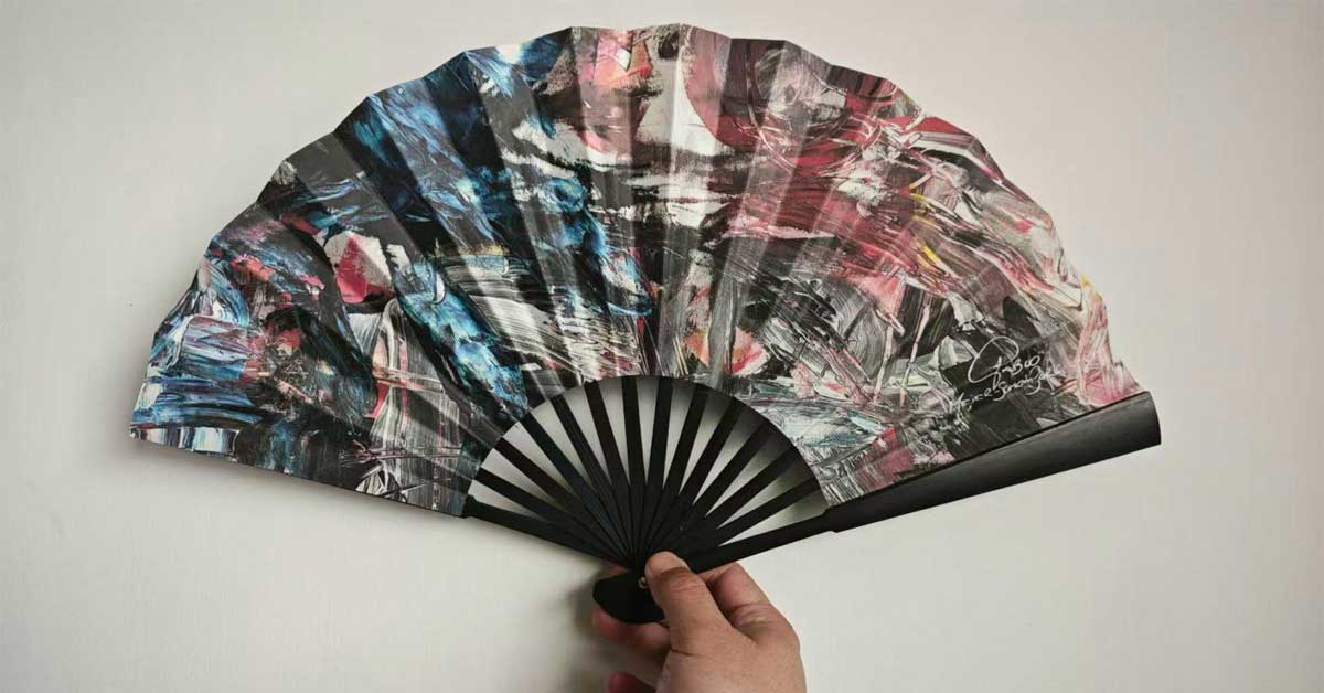Abstract art fan designed for Viennese Opera Ball New York held in a hand