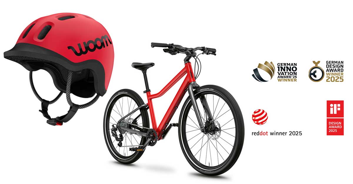READY children's helmet by woom in red with safety features. woom EXPLORE bike with matte black details and award 2025 badges.
