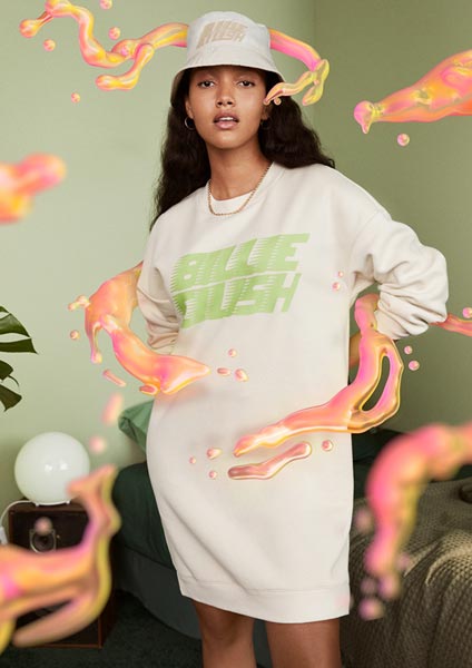 The image shows a model wearing a beige sweater dress and cap, both with 'Billie Eilish' logo. The model is surrounded by graphics designed by Paris-based artist Ines Alpha...